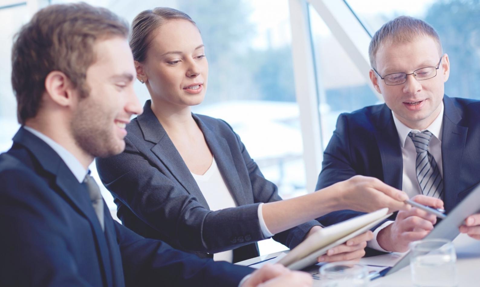 Teilnehmer arbeiten gemeinsam an Budgetplänen in modernem Schulungsraum